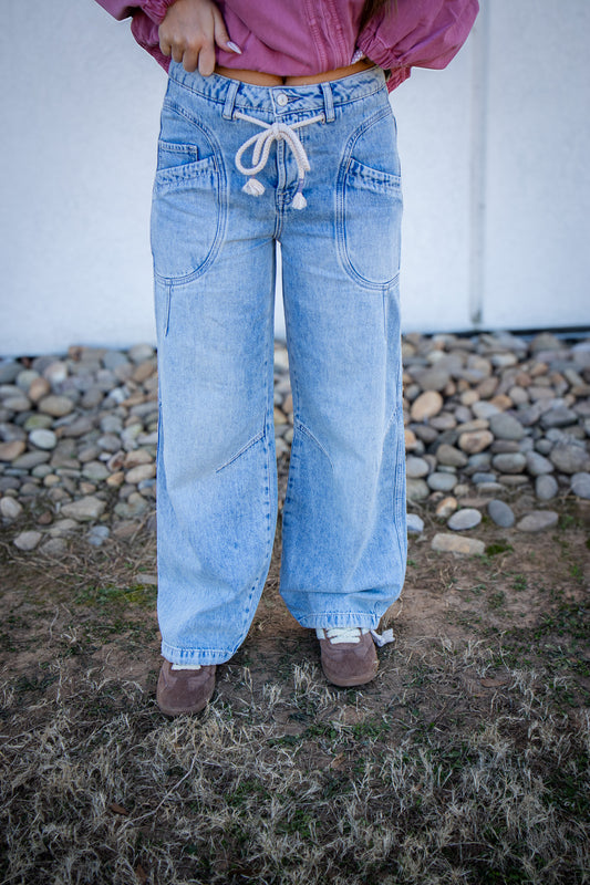 Person wearing light blue jeans with a white background