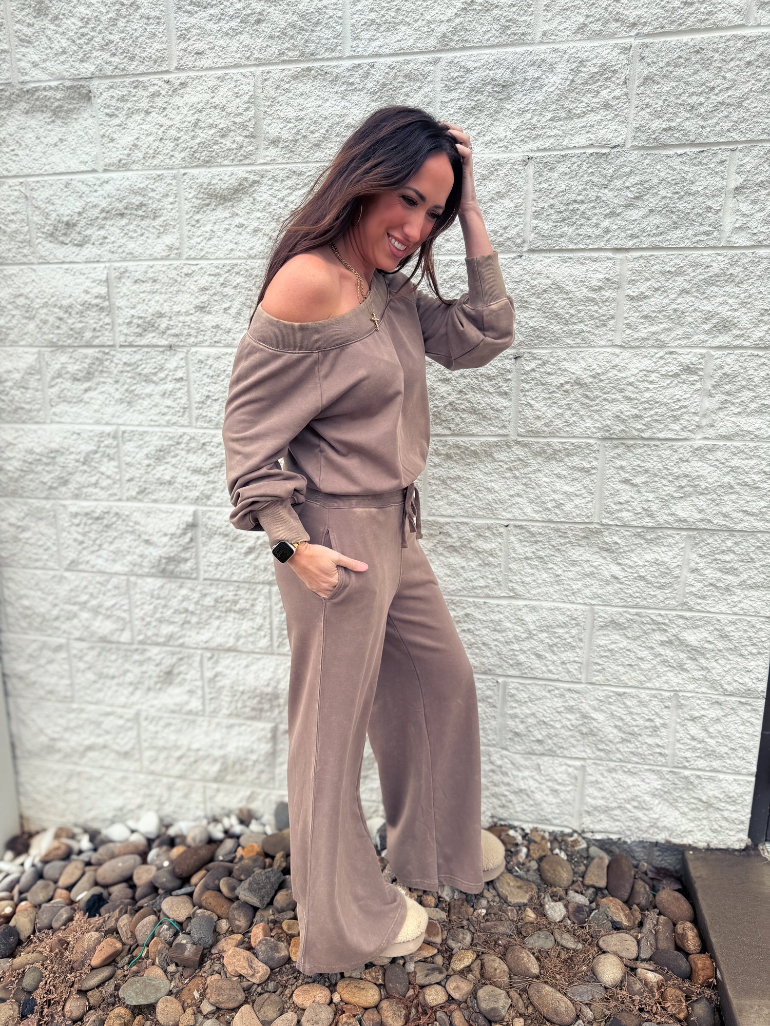 Brown jumpsuit worn off one shoulder