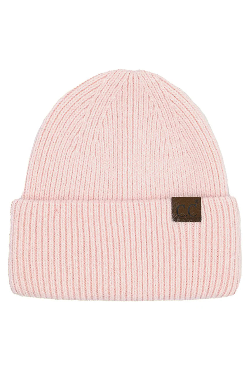 Pink beanie with a brown label on a white background
