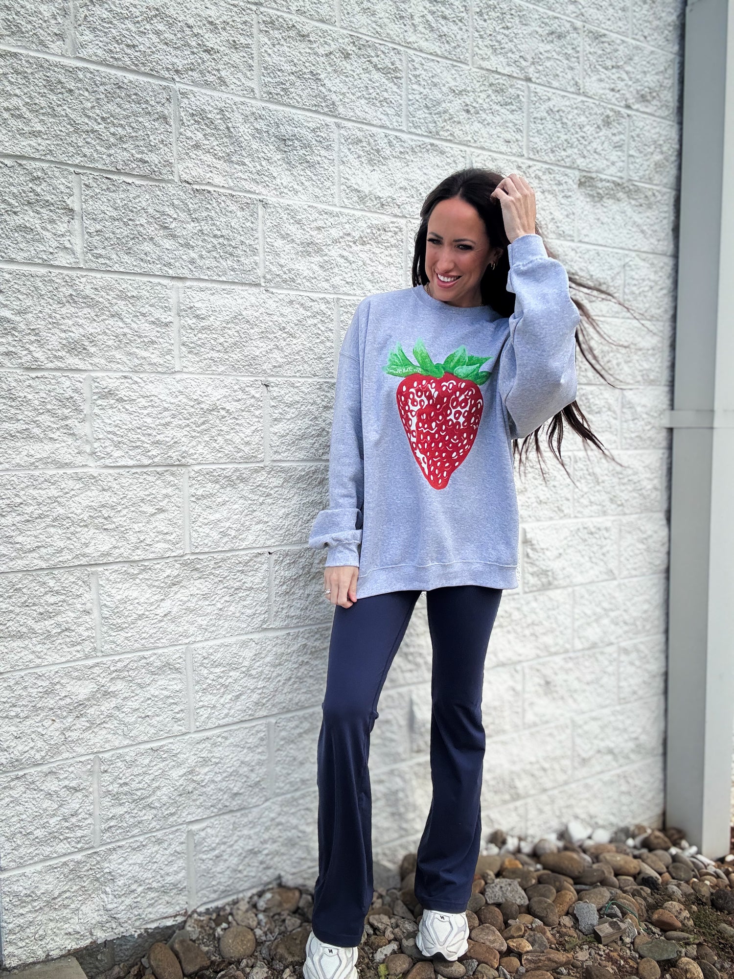 Gray sweatshirt with a strawberry design paired with navy flare leggings