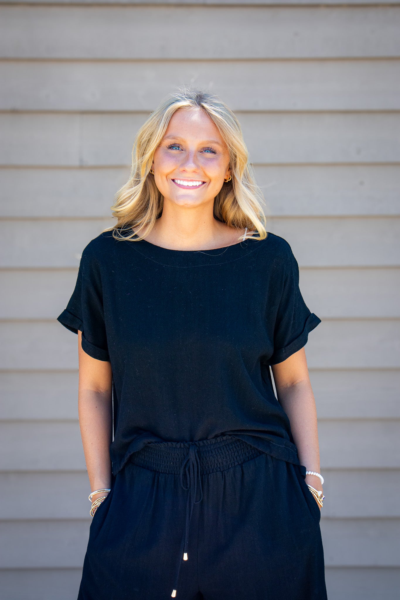 Women’s black linen blend short sleeve top with relaxed boxy fit styled with matching black drawstring pants.