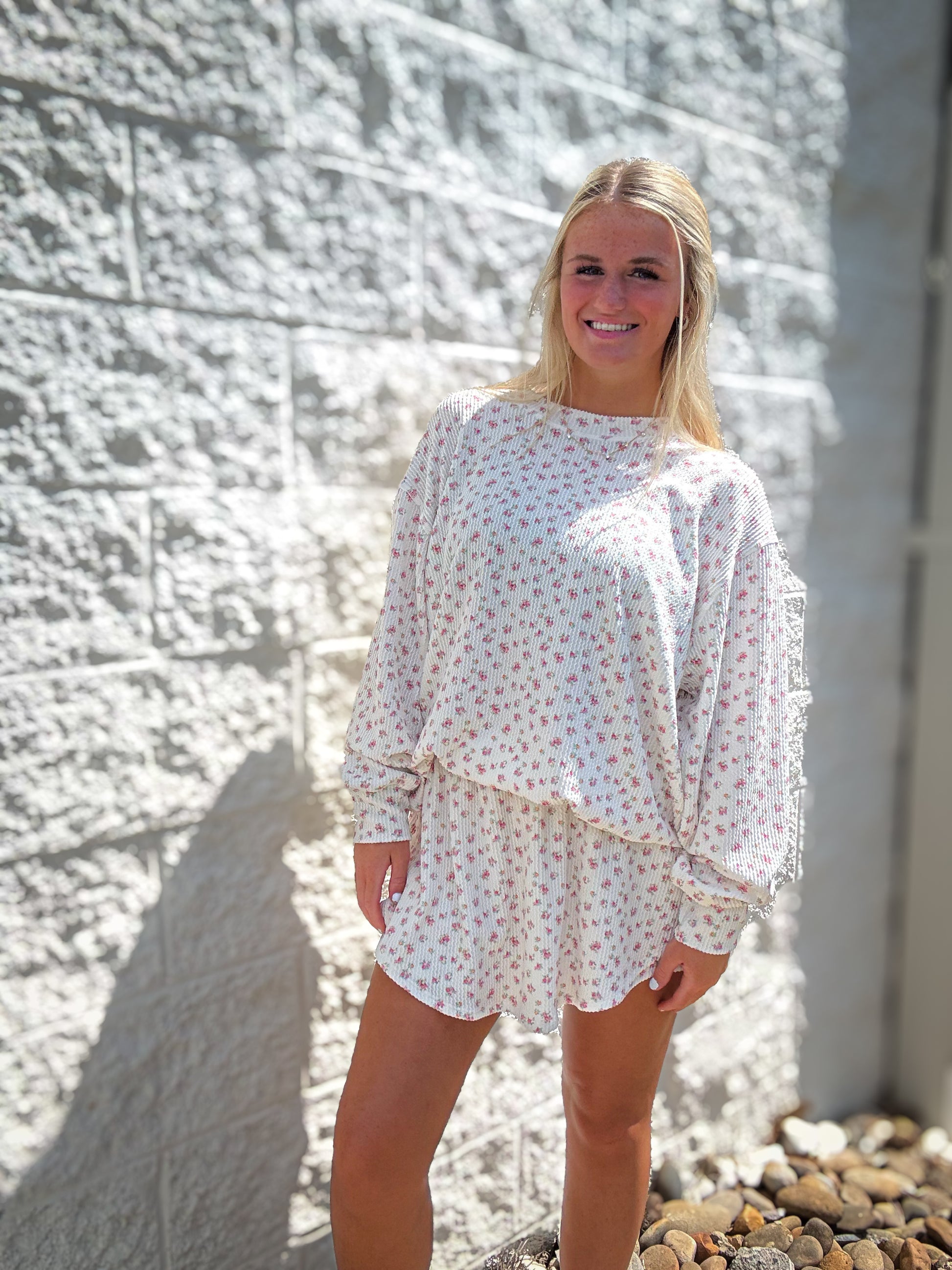 A woman wearing a floral ribbed top and skort set with an oversized fit and high-waisted skort.