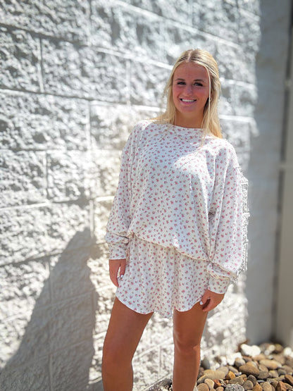A woman wearing a floral ribbed top and skort set with an oversized fit and high-waisted skort.