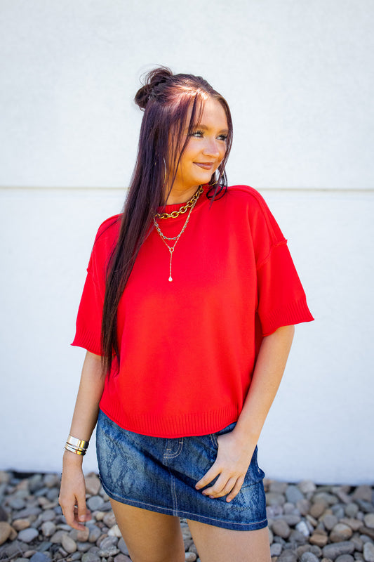 Red short sleeve sweater top styled with a denim mini skirt and layered gold jewelry for a bold summer boutique outfit, perfect for Fourth of July, gameday, and casual everyday style.
