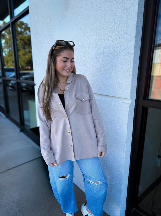 Beige suede shacket with a collar, gold button-up front, and side pockets