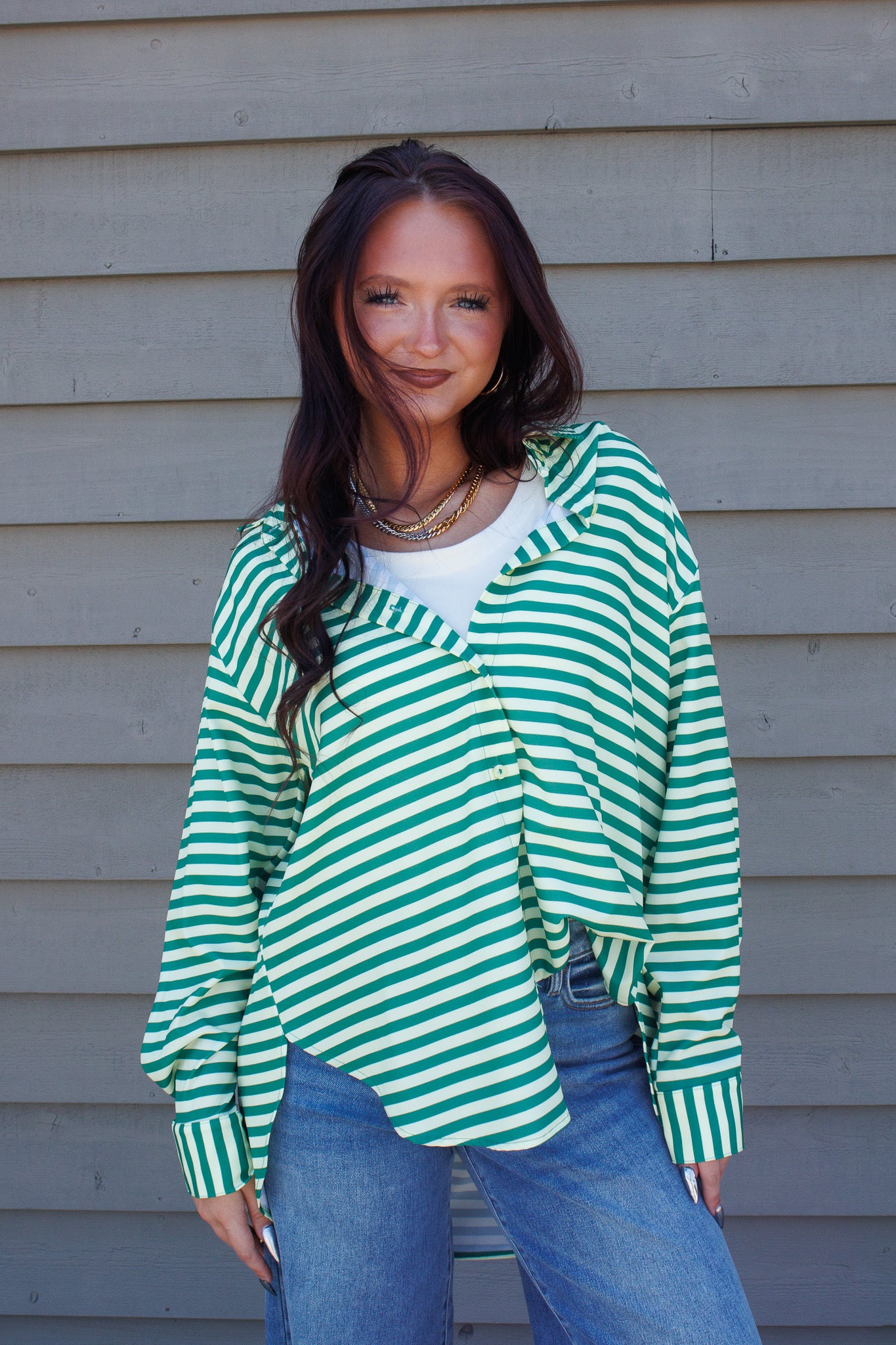 Make a statement in the Emerald Lineup Striped Button Down. This oversized green and cream blouse is the perfect lightweight essential for work or vacation.