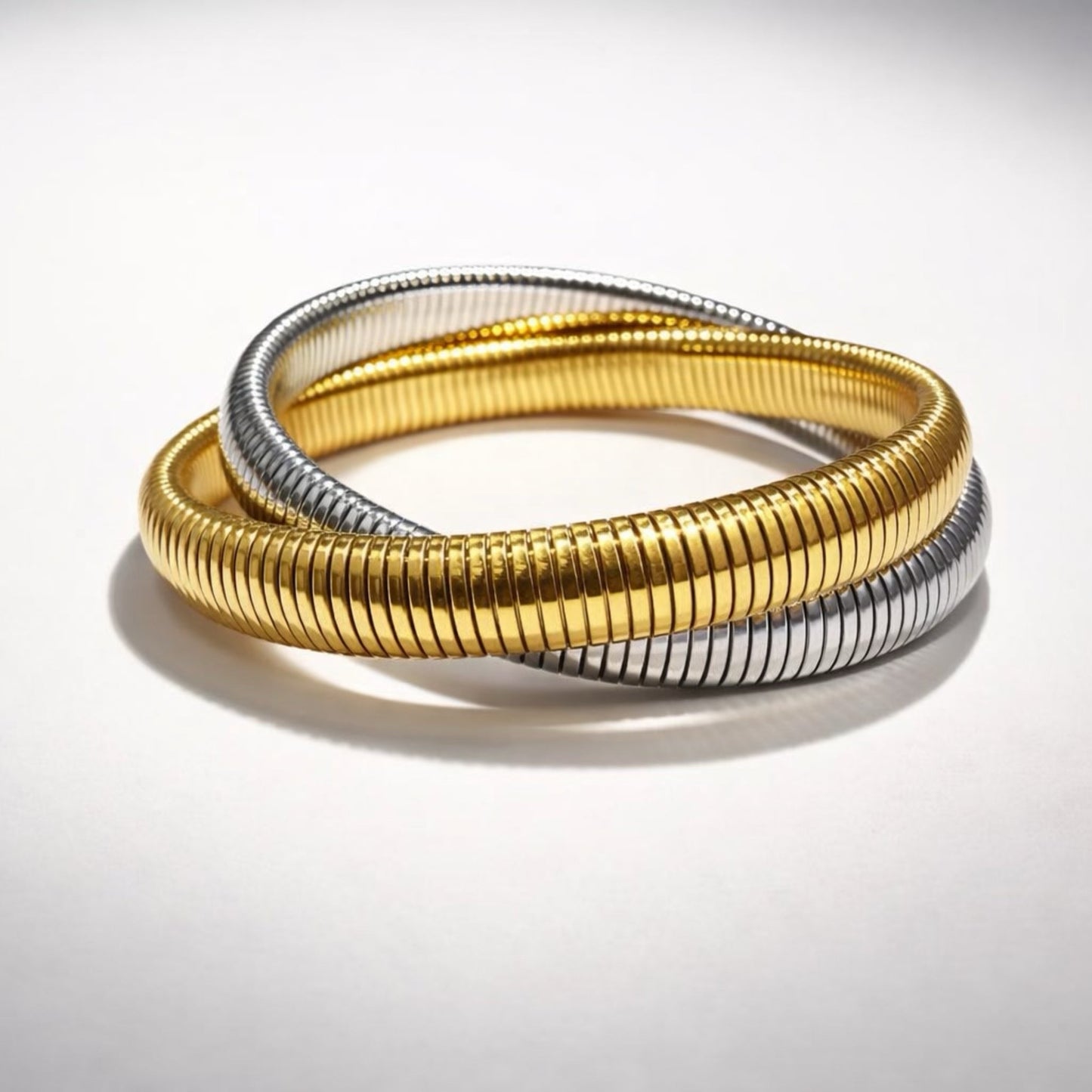 Trendy two-tone gold and silver coil bracelet, flexible wrap style with textured finish