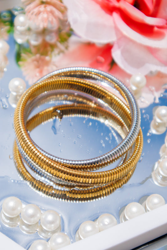 Trendy two-tone gold and silver coil bracelet, flexible wrap style with textured finish