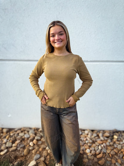 Model wearing a camel waffle knit long sleeve top with a crew neckline and lettuce-edge hem, styled with charcoal barrel leg jeans for a casual fall outfit.