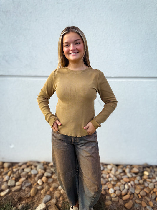 Model wearing a camel waffle knit long sleeve top with a crew neckline and lettuce-edge hem, styled with charcoal barrel leg jeans for a casual fall outfit.