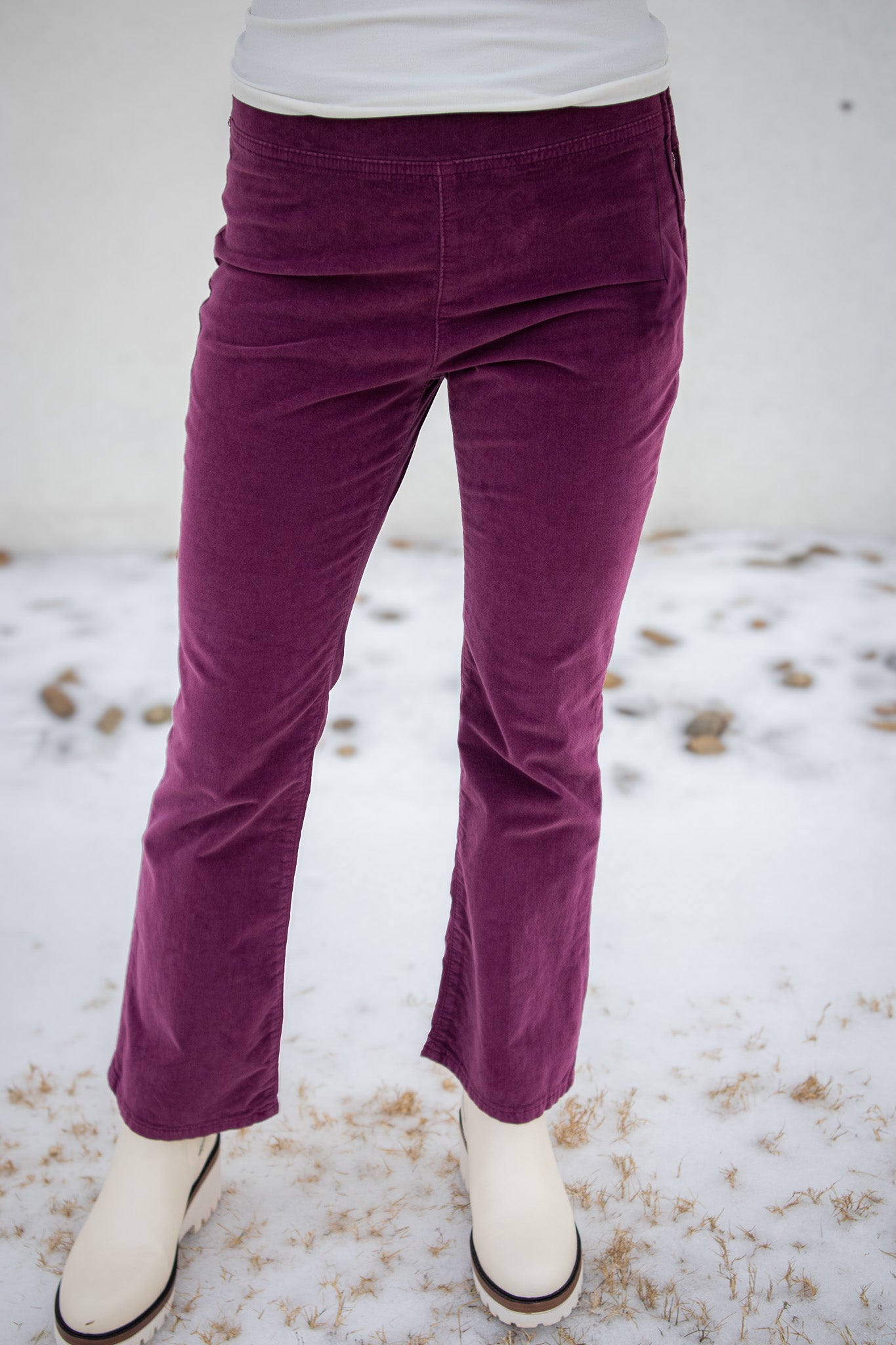 Purple corduroy pants worn by a person on a snowy ground.