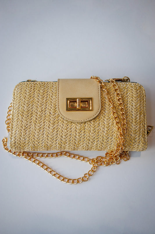 Beige knitted handbag with a gold chain on a light gray background