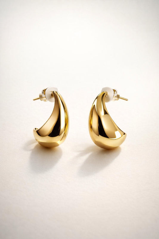 Gold teardrop stud earrings with a smooth, high-shine polished finish