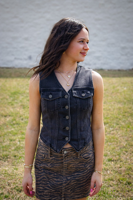 Woman wearing a denim vest and zebra print skirt outdoors