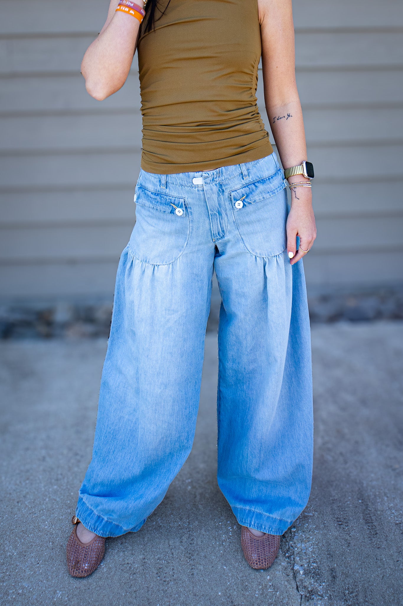 High rise light wash wide leg jeans with oversized front pockets and flowy fit styled with olive fitted tank and neutral woven flats