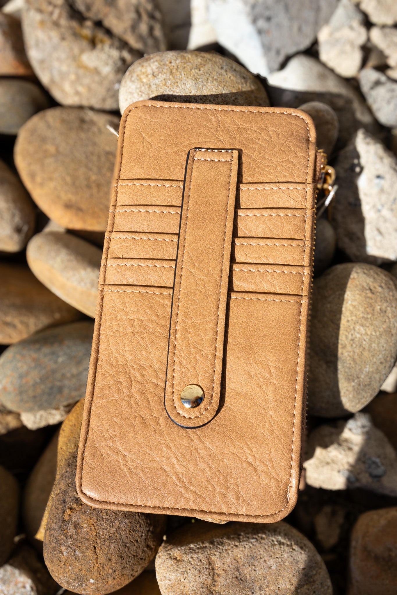 Brown leather wallet on a bed of stones