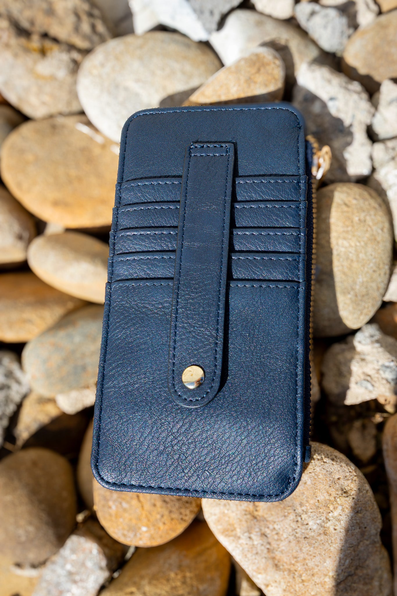 Blue leather wallet on a bed of stones