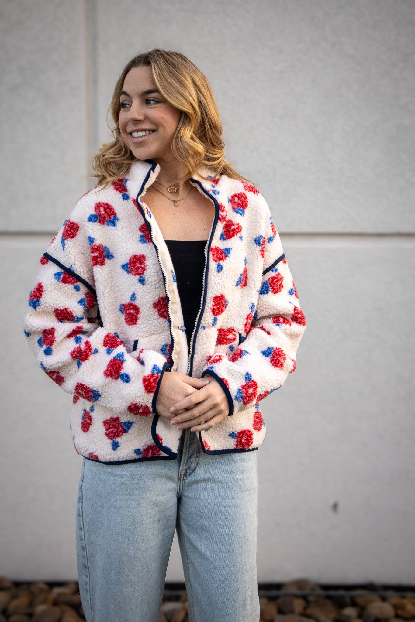 Woman wearing a floral patterned jacket against a plain background