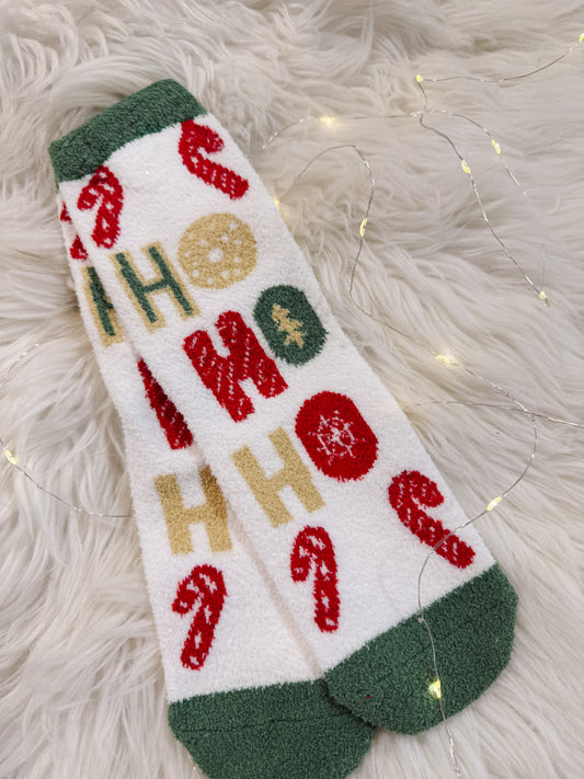 Christmas-themed sock with 'HO HO HO' text on a fluffy white surface.
