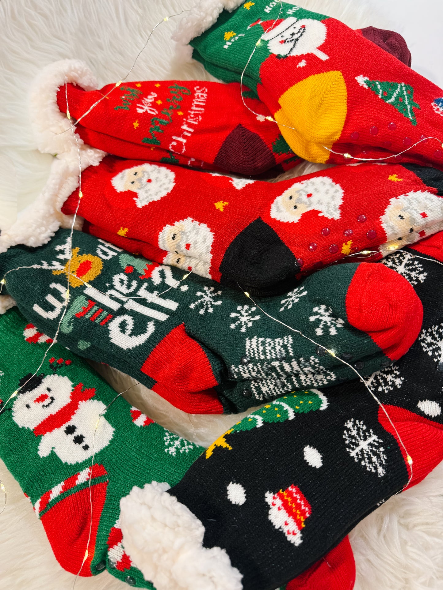 Collection of Christmas-themed socks with festive designs on a white surface.