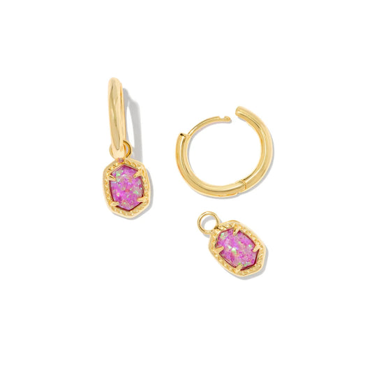 Gold hoop earrings with pink gemstones on a white background