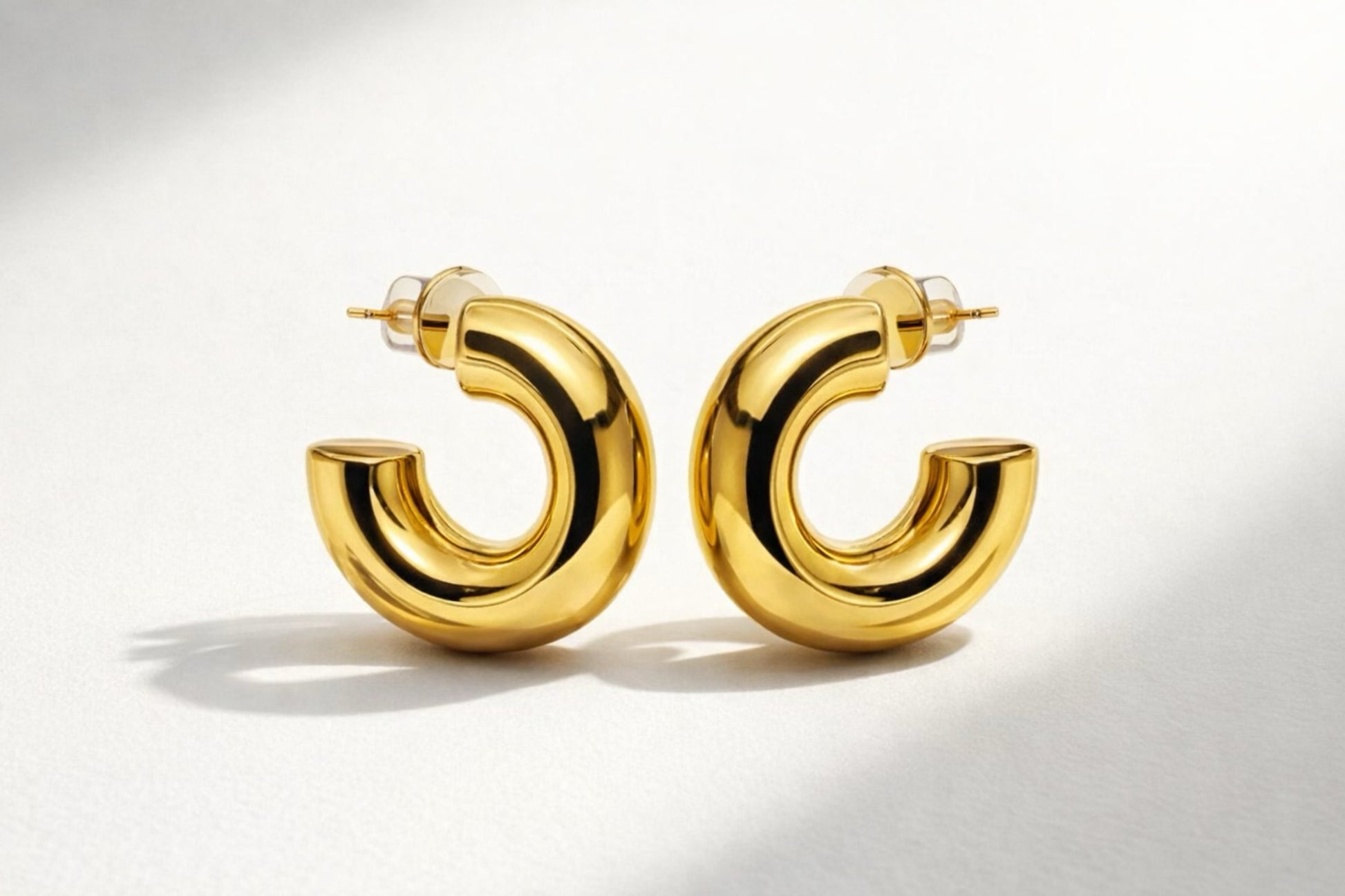 Trendy chunky gold hoop earrings with a smooth, high-shine polished finish