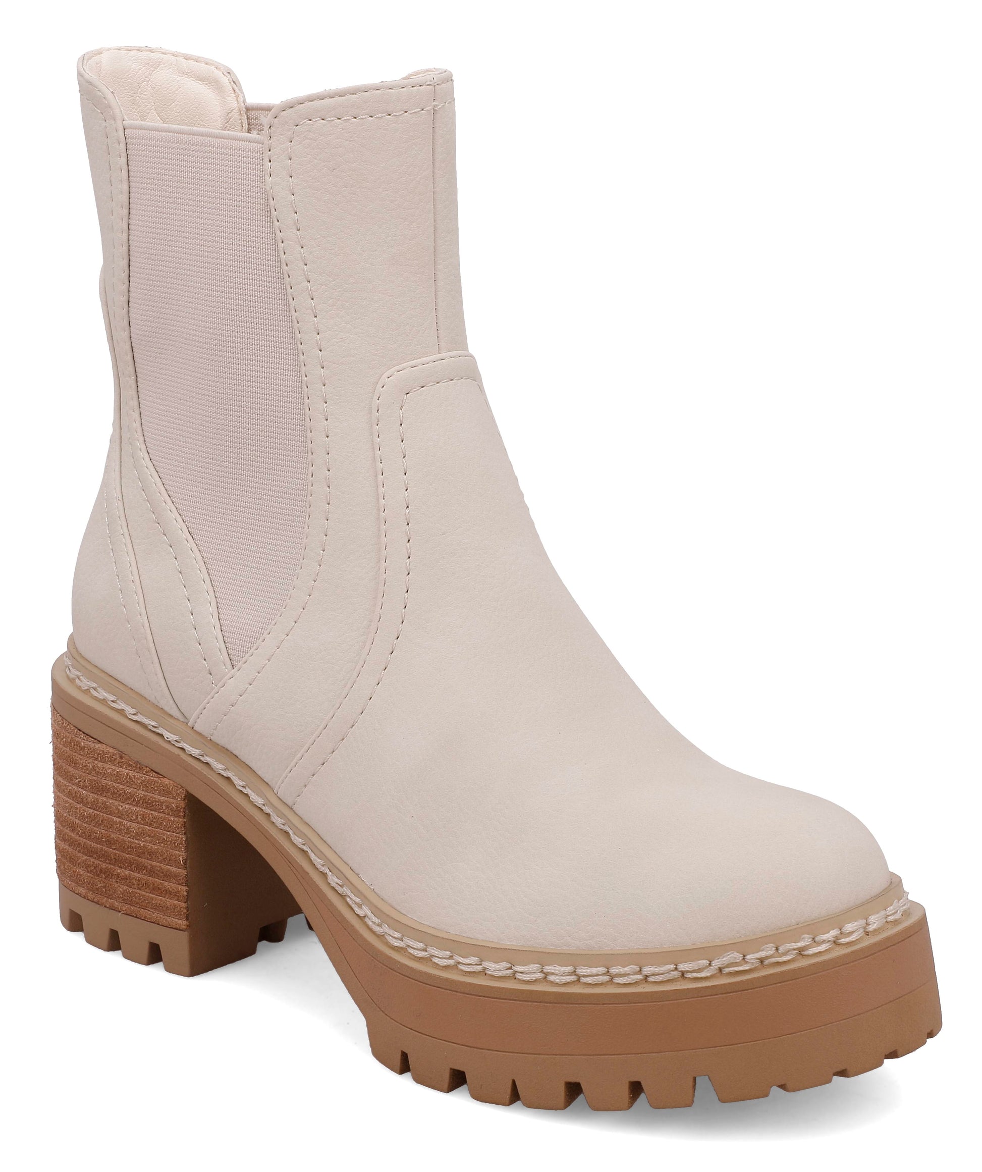 Ecru faux leather Chelsea ankle boot featuring elastic side panels, a chunky lug sole, stacked block heel, and round toe for a modern, versatile everyday style.