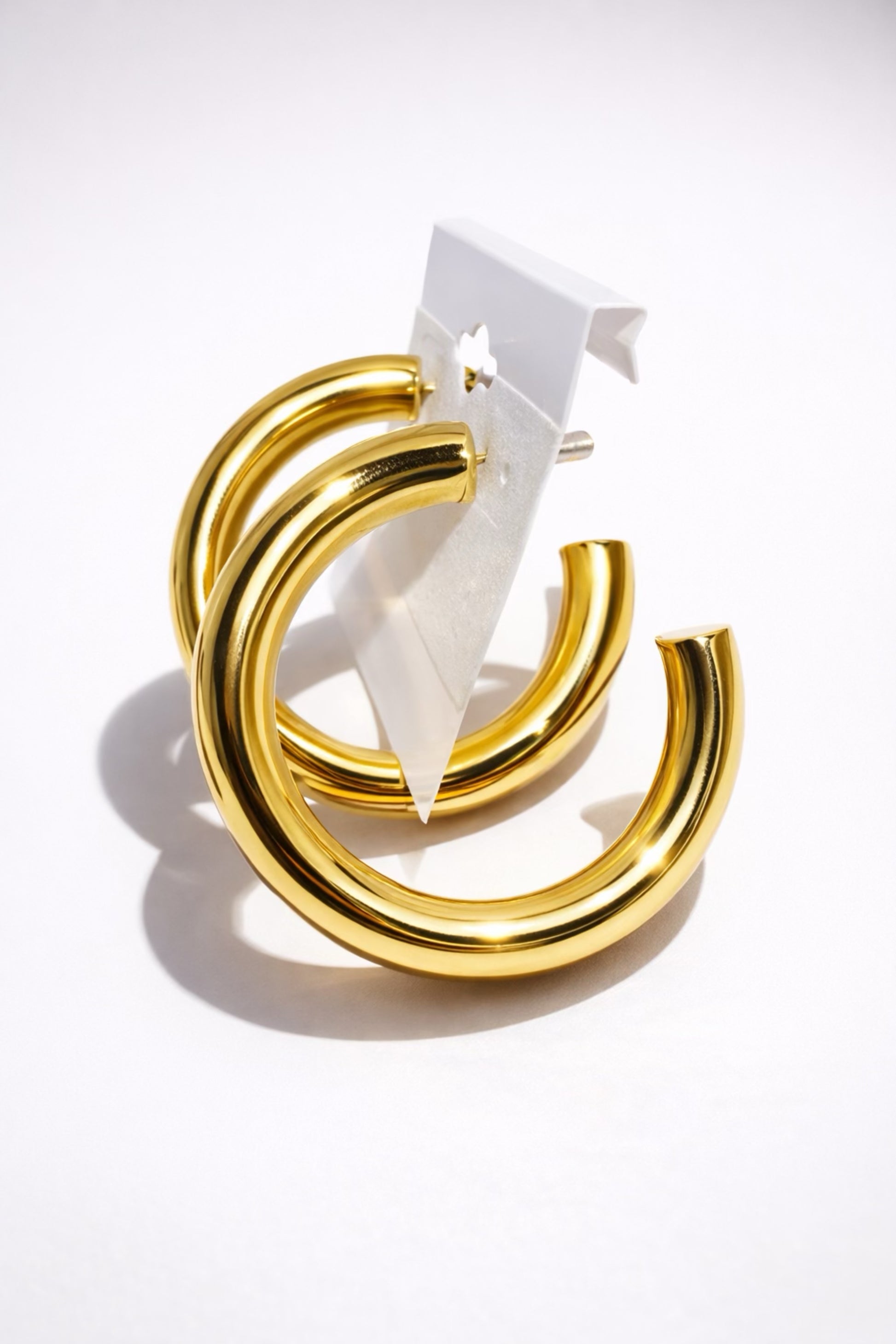 Chunky gold hoop earrings with a thick rounded design and high-shine polished finish