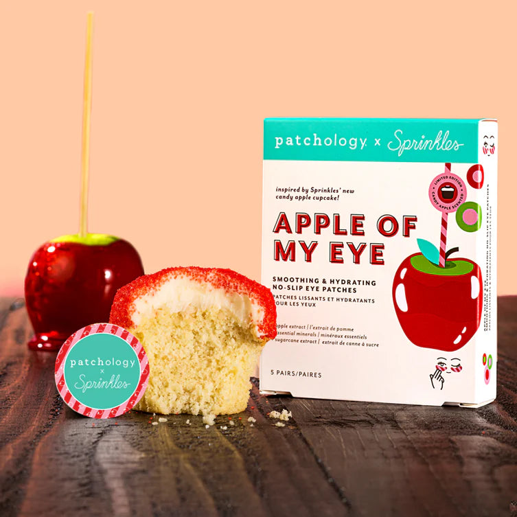 Patchology x Sprinkles 'Apple of My Eye' product with a cupcake and candy apple on a wooden surface.