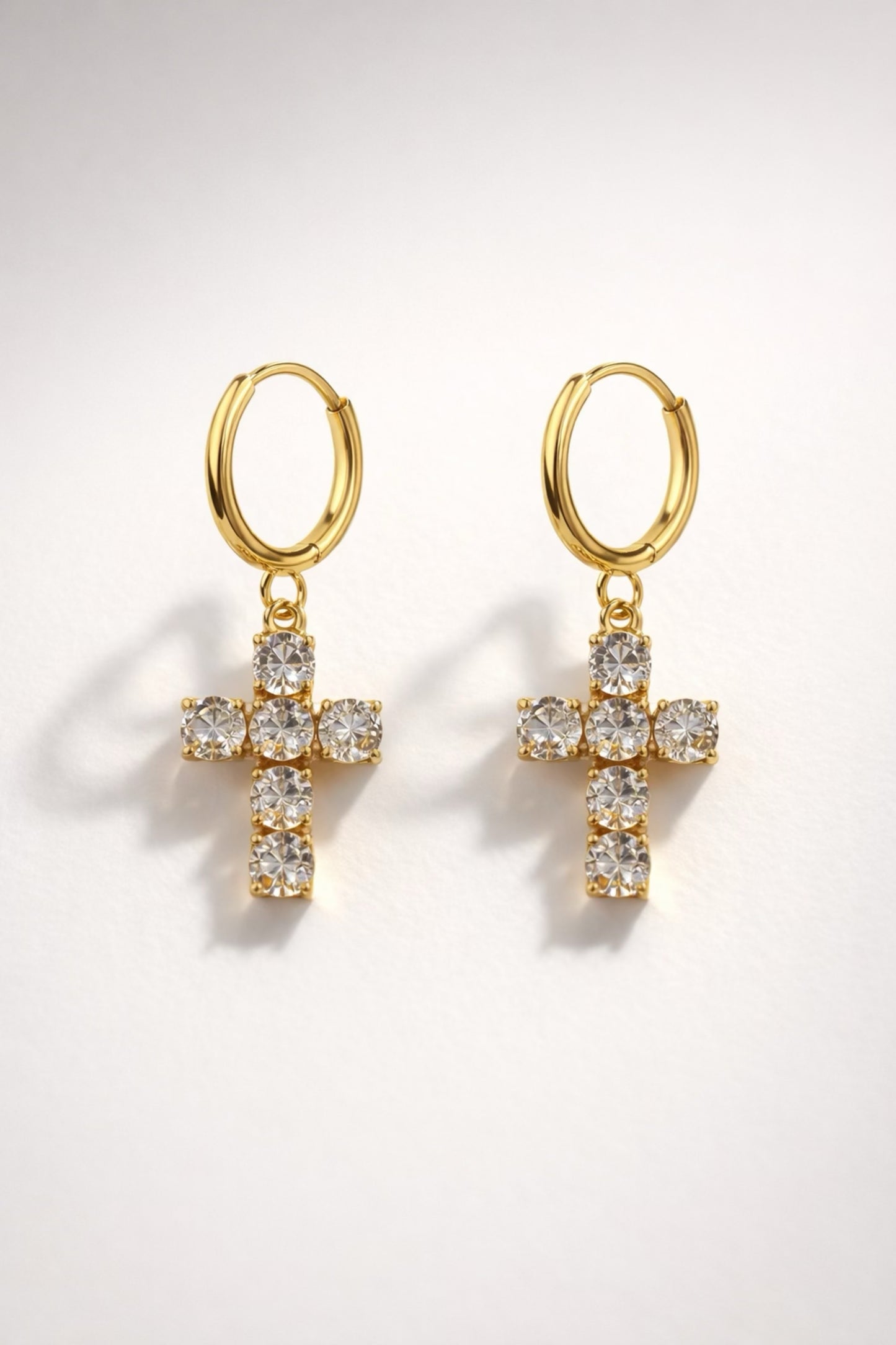 Gold huggie hoop earrings with crystal cross drop and high-shine polished finish