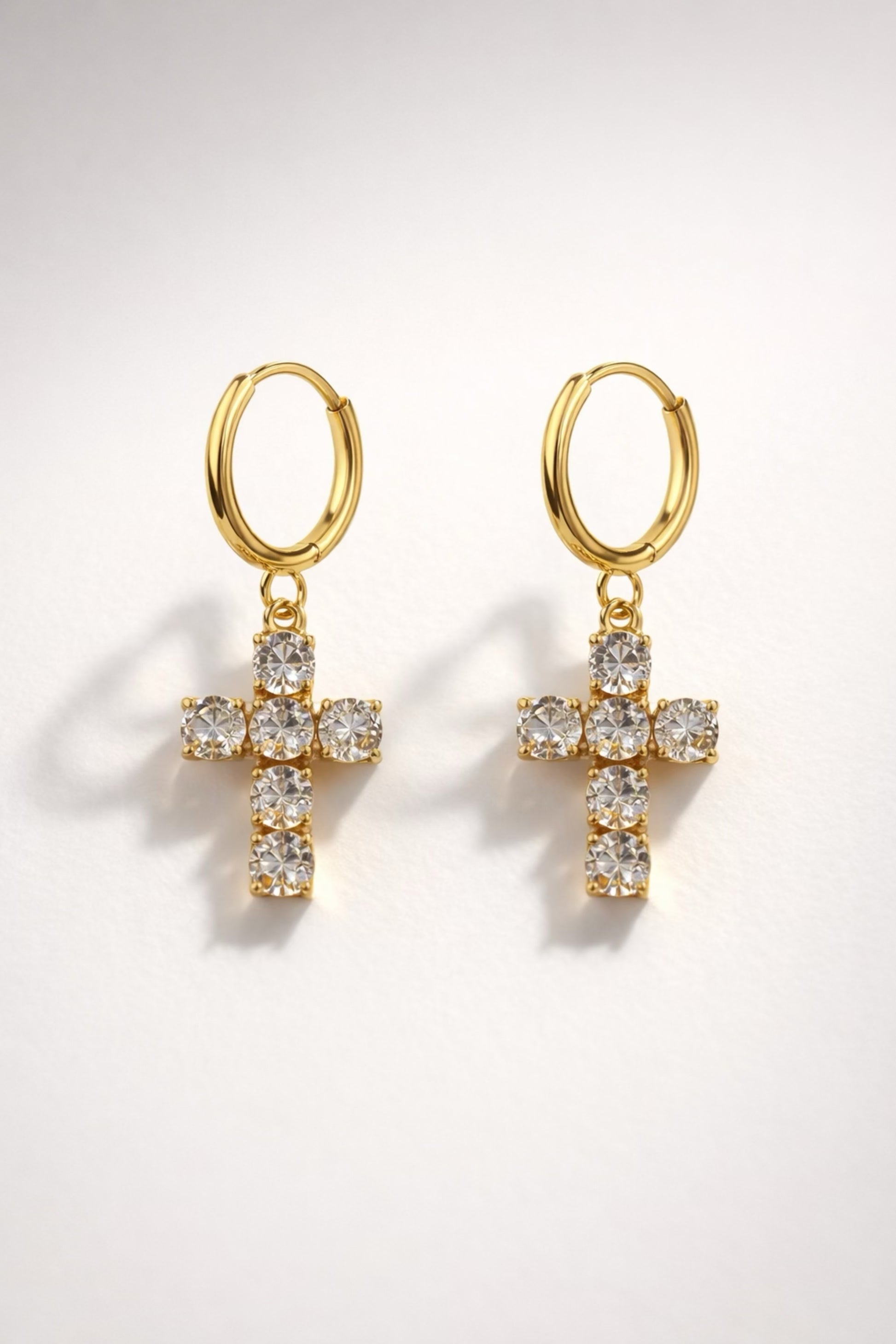 Gold huggie hoop earrings with crystal cross drop and high-shine polished finish