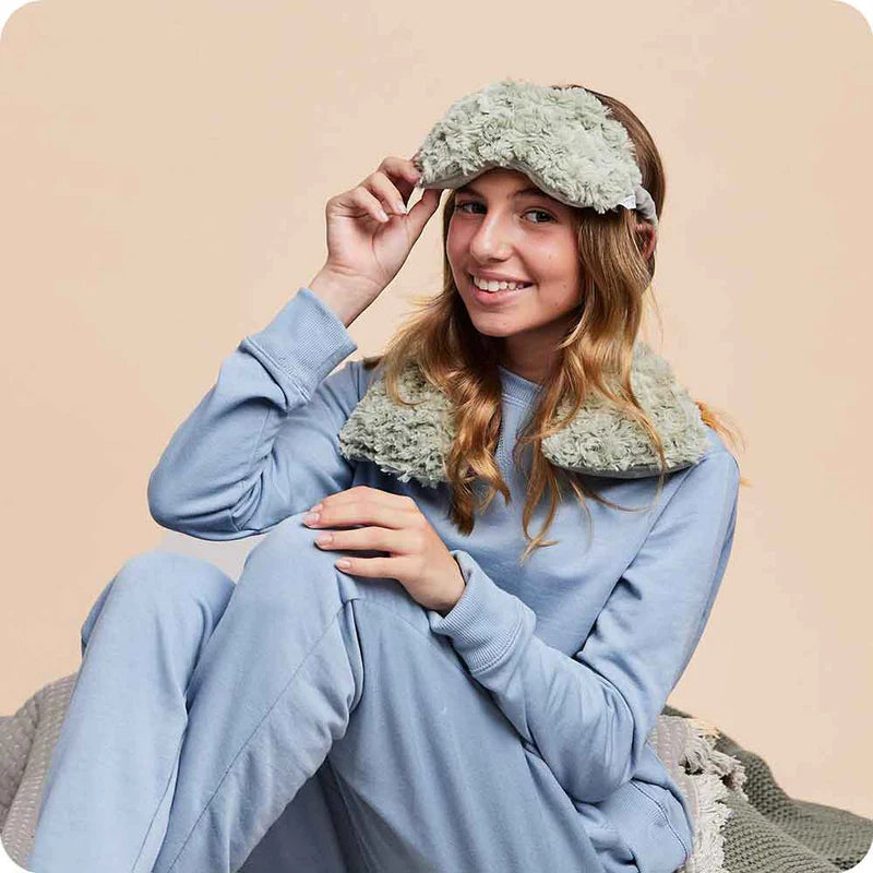Woman  with a plush Warmies® neck wrap draped around her shoulders, providing soothing heat therapy and cozy comfort for neck and shoulder relief.